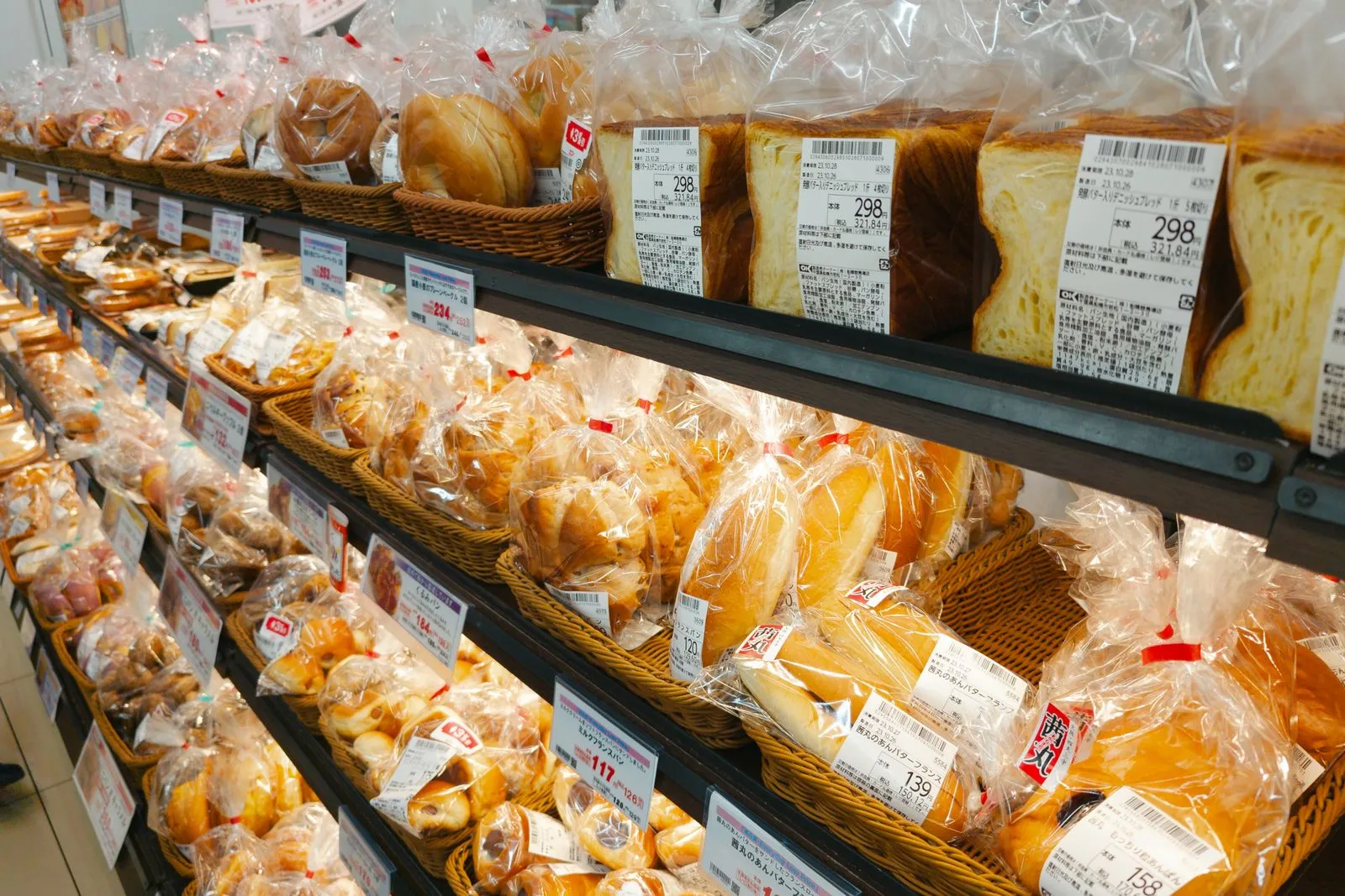 A diverse selection of prepackaged bread in a grocery store aisle, perfect for food-related projects.